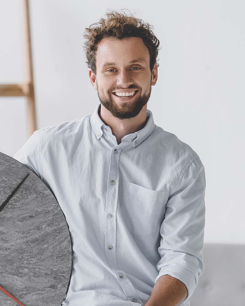 portrait of smiling businessman with big clock sit 8VR4UKT